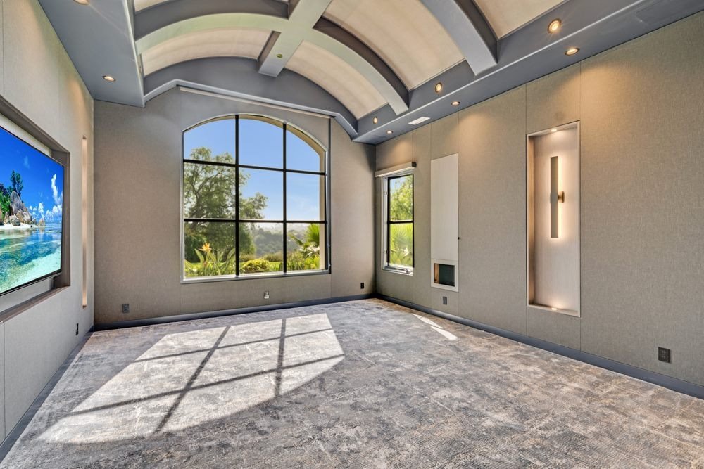 Modern home theater with large windows and screen