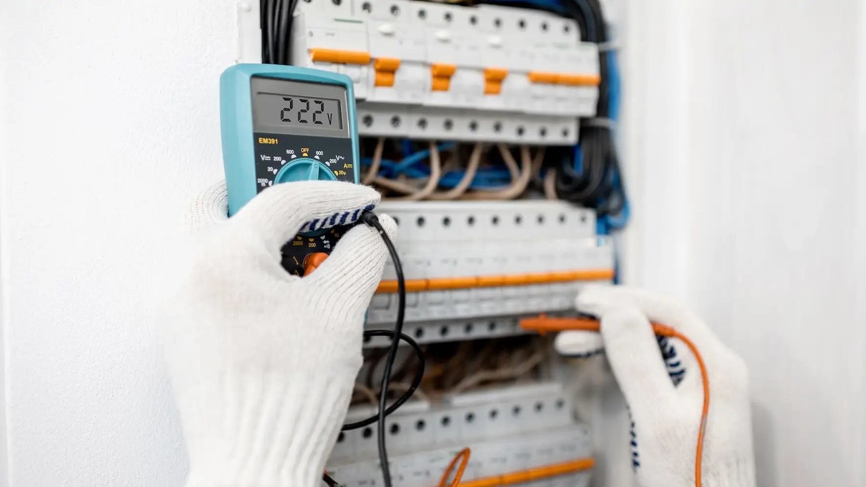Electrician testing voltage in electrical panel