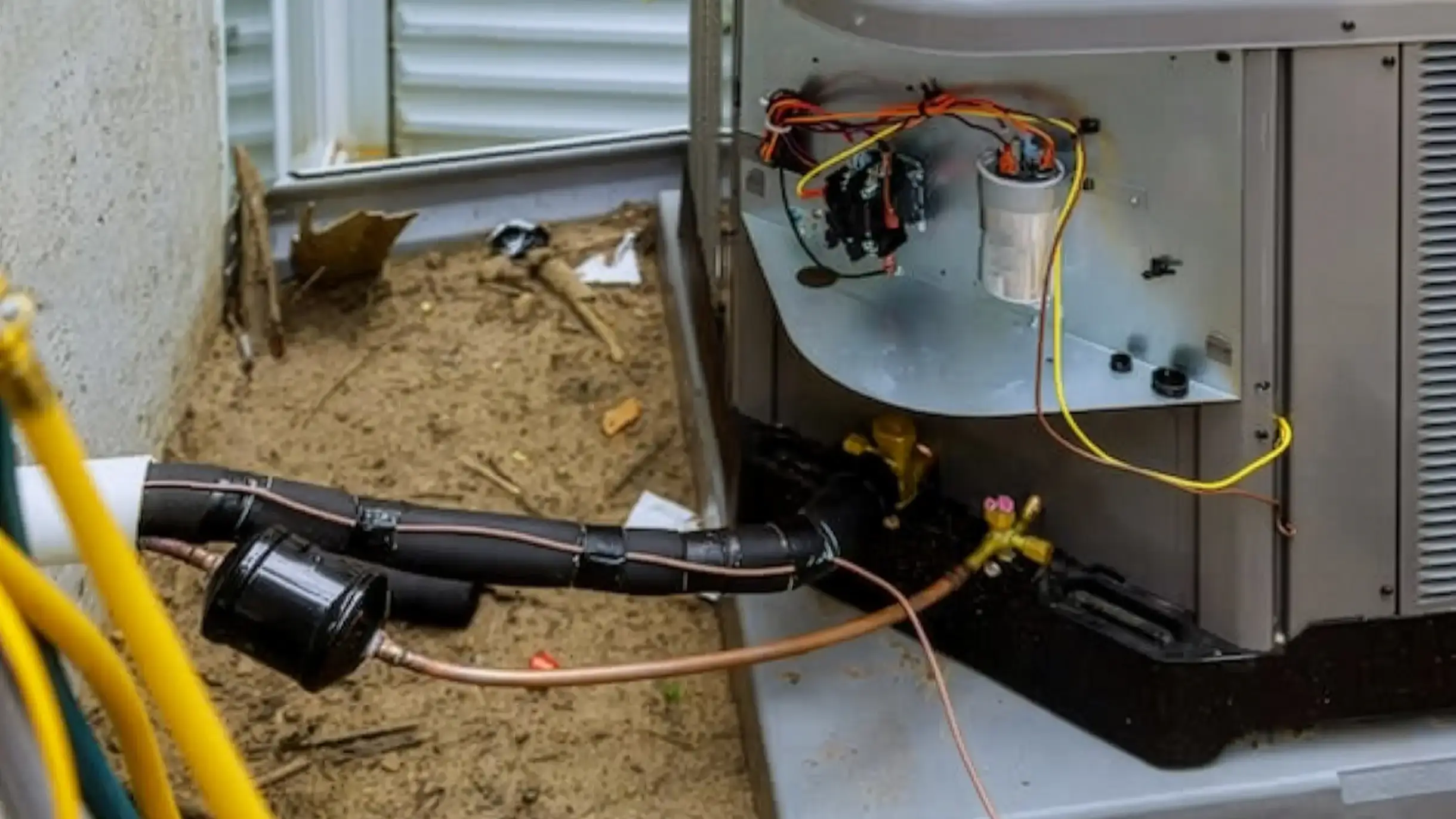 Air conditioner unit with exposed wiring and pipes