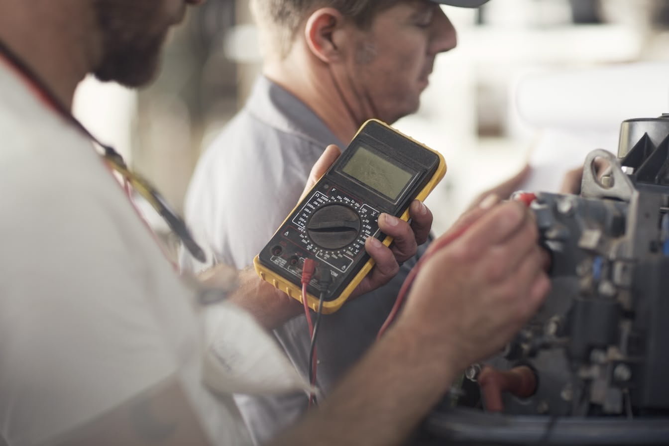 Technician using multimeter for equipment testing